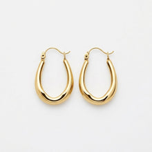 Gold hoop earrings on a light gray background