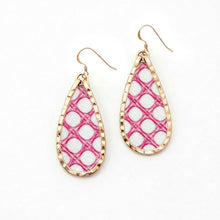 Teardrop-shaped earrings with pink and white lattice design on a gold frame against a white background.
